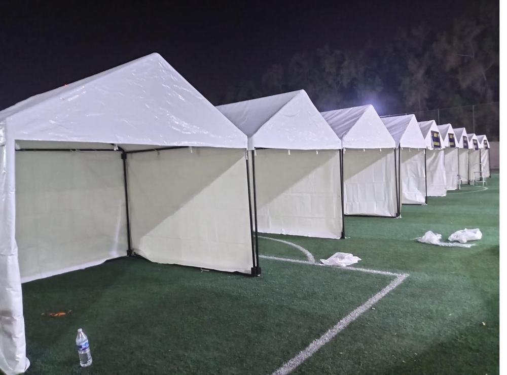 White tent structures on outdoor field